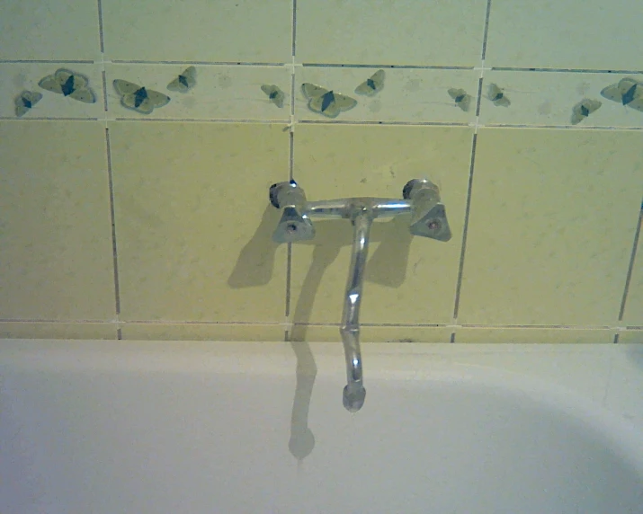 a metal handle on a faucet near a bathtub