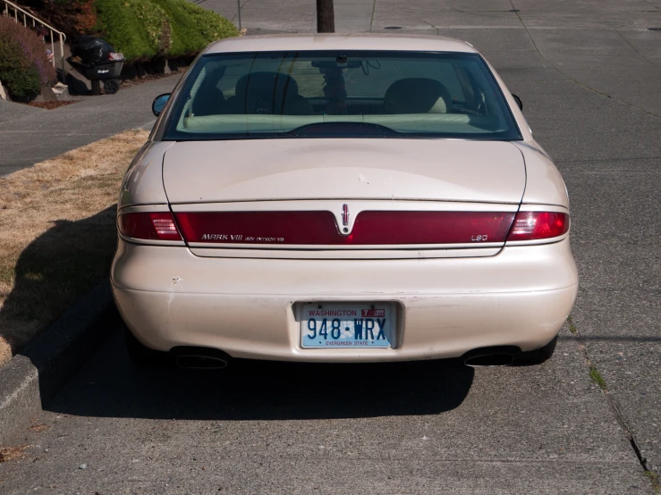 an older model car is parked at the curb