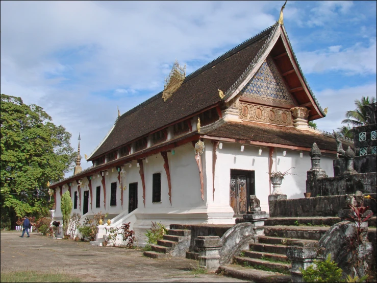 the large white building has several stairs leading to it