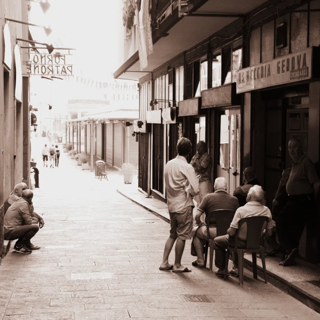 several people standing and sitting on the sidewalk