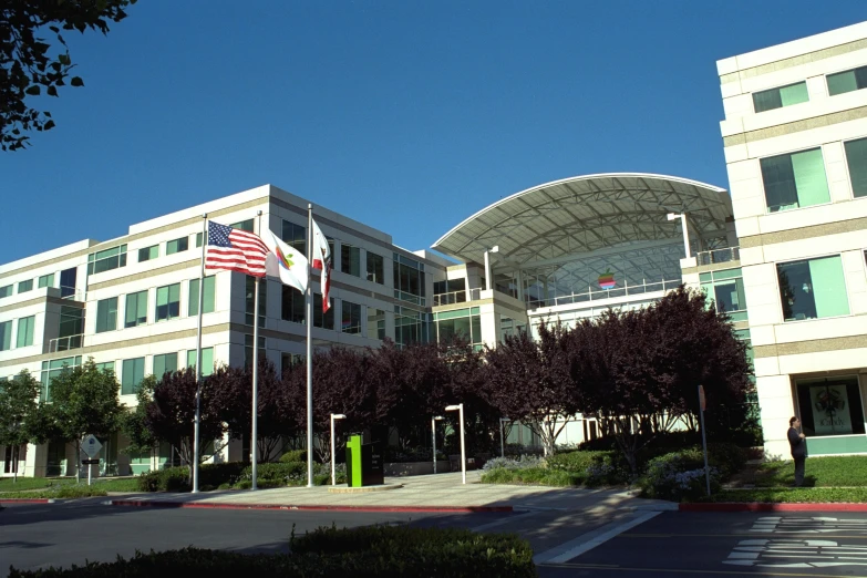 a few flags and a building under a blue sky