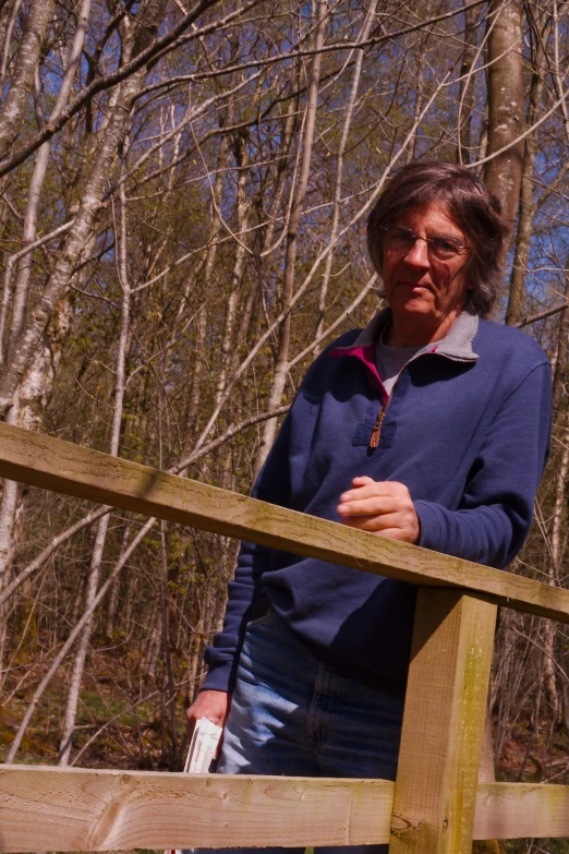 a woman is standing outside near a wooden fence