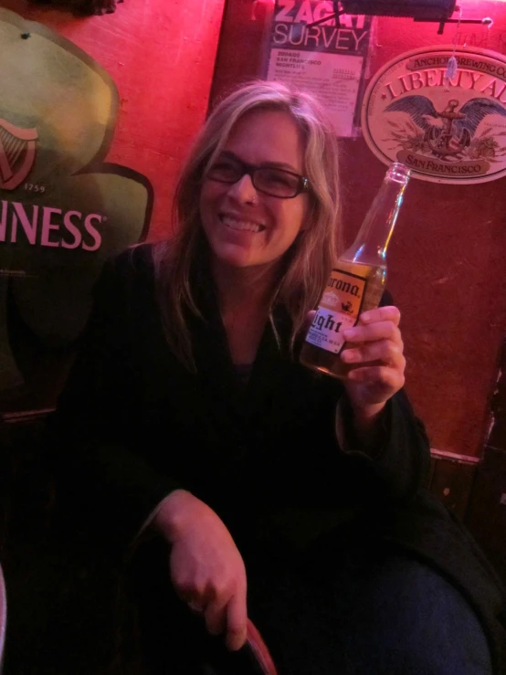 a woman holding a beer in her hand at a bar