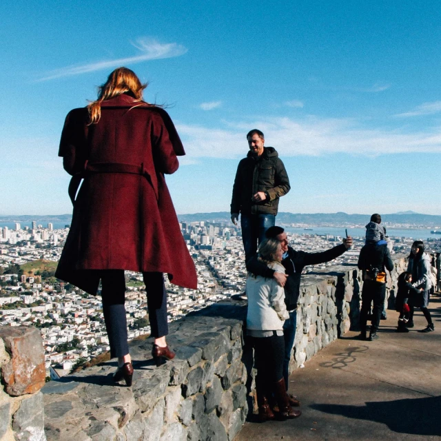 people are standing on a hill overlooking the city