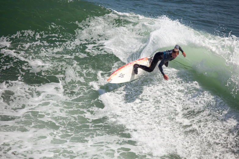 a man in a wet suit riding a surfboard