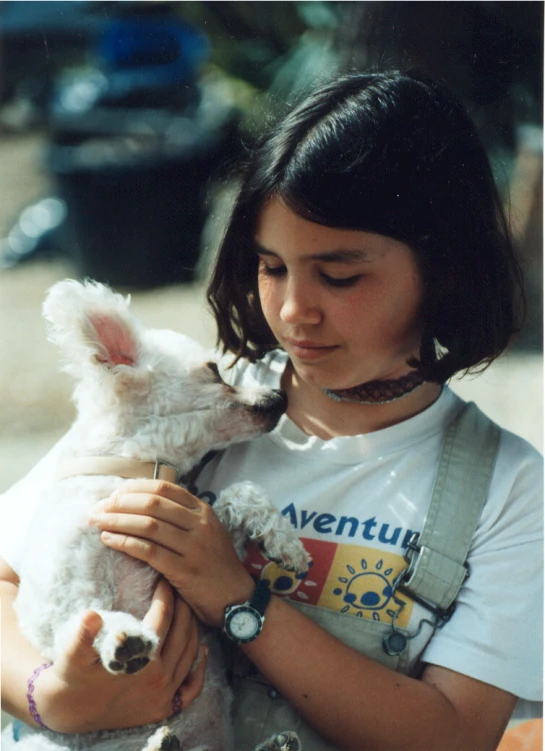 the  is holding her small white dog