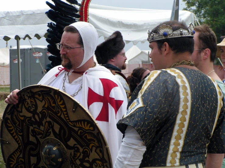 the man in costume is talking to two men wearing medieval clothing