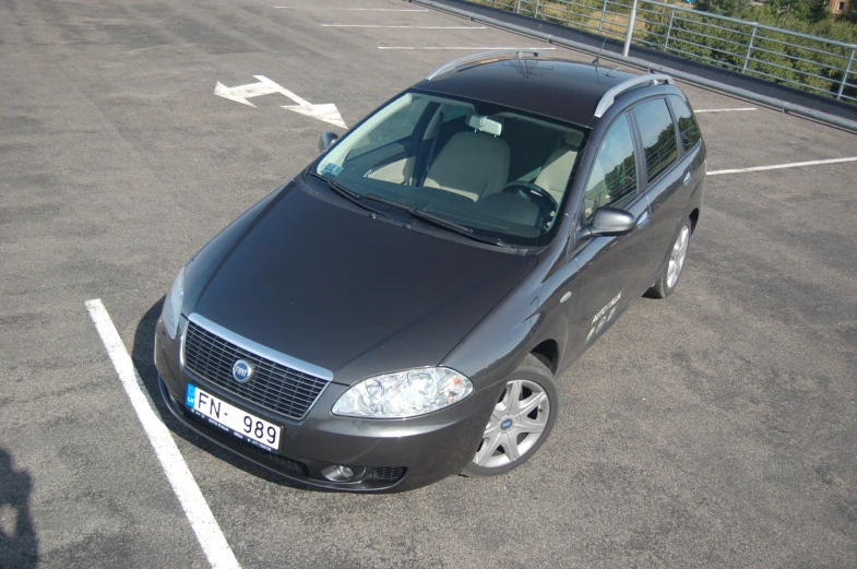 the black car has been parked in a parking lot