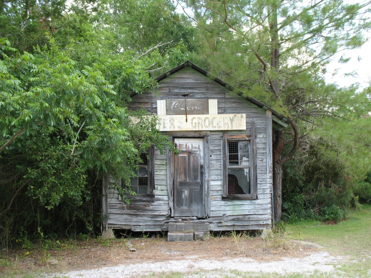 an old wooden building sitting in the middle of a forest