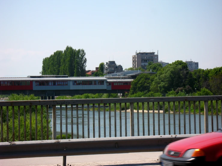 a train is crossing over the water with some trees