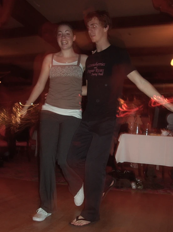 a young man and woman are dancing on the dance floor