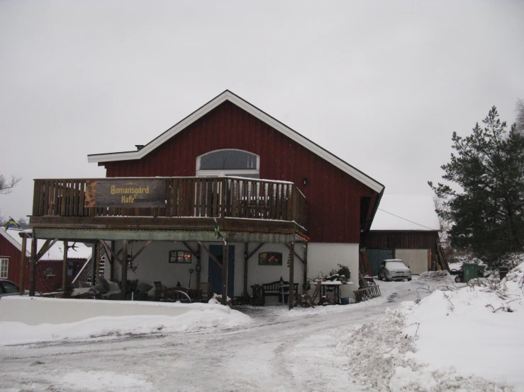 a red barn has stairs on it, next to a road