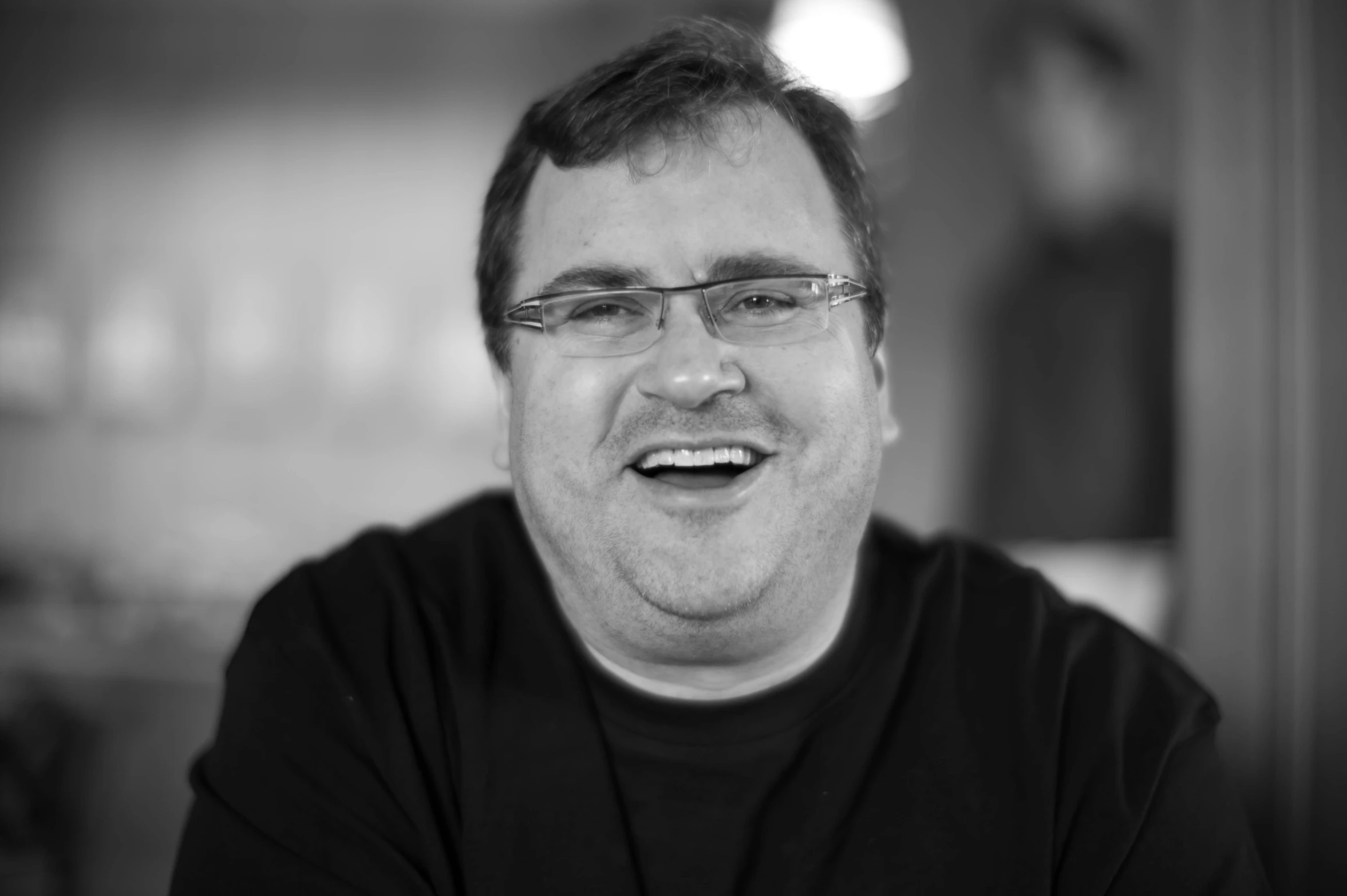 black and white po of smiling man with glasses