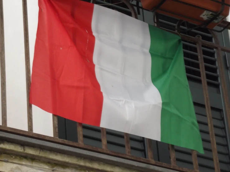 the flag of italy waving on a balcony