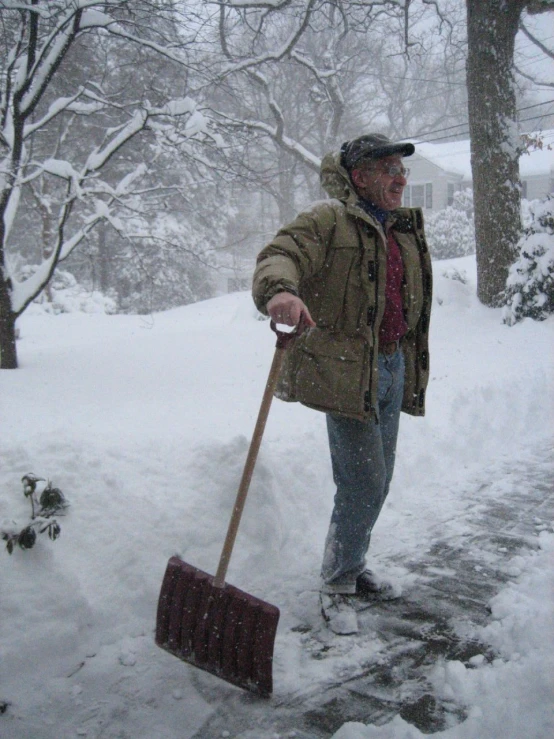 a man using a shovel to dig out snow on a path