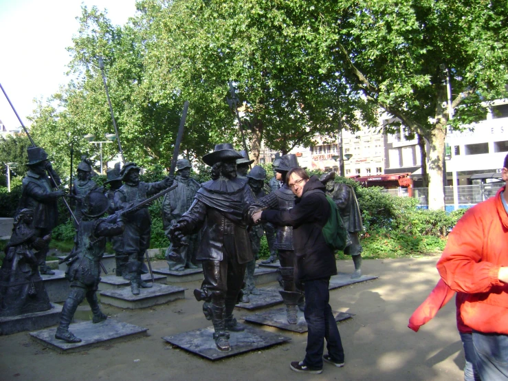 a group of people standing around a statue of soldiers