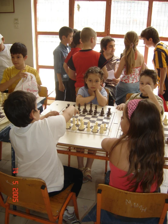 a young child playing chess with his group