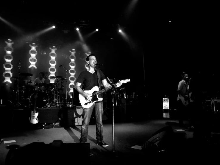 man playing guitar in front of band on stage