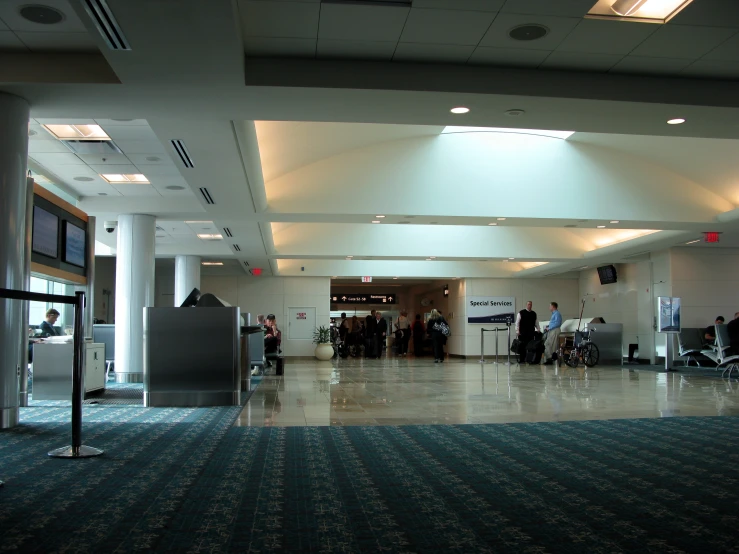 an airport lobby with many passengers standing around