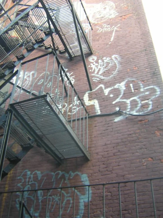 graffiti writing all over the side of a brick building