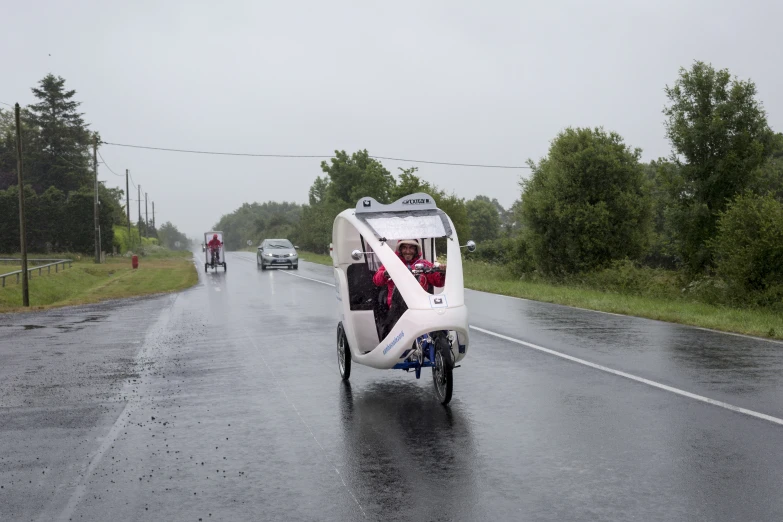 an open - air vehicle riding on the road with a side car