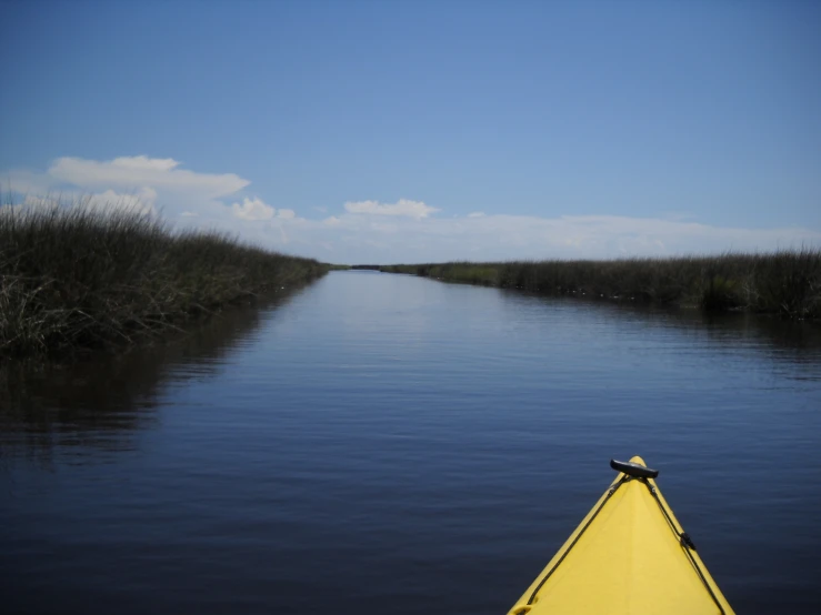 a bright yellow boat floating down a large waterway