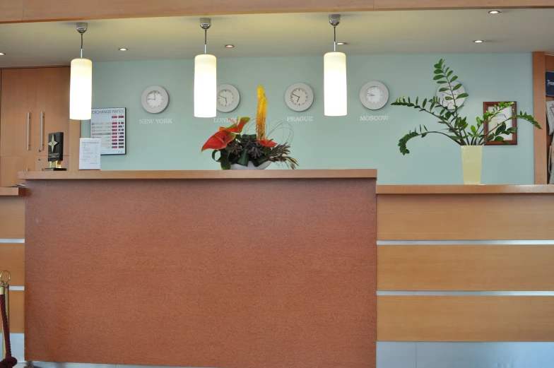 an office front desk with clocks and flowers