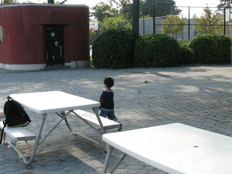 a small child is standing near a white table