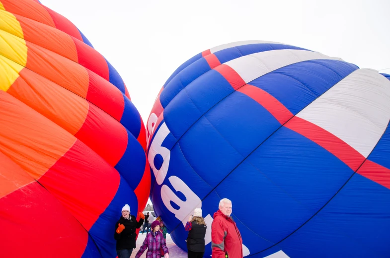 people standing around some large colorful  air balloons