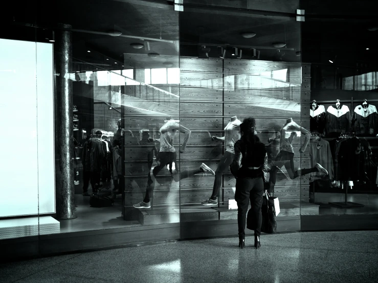 woman with suitcase looking into window display in urban area