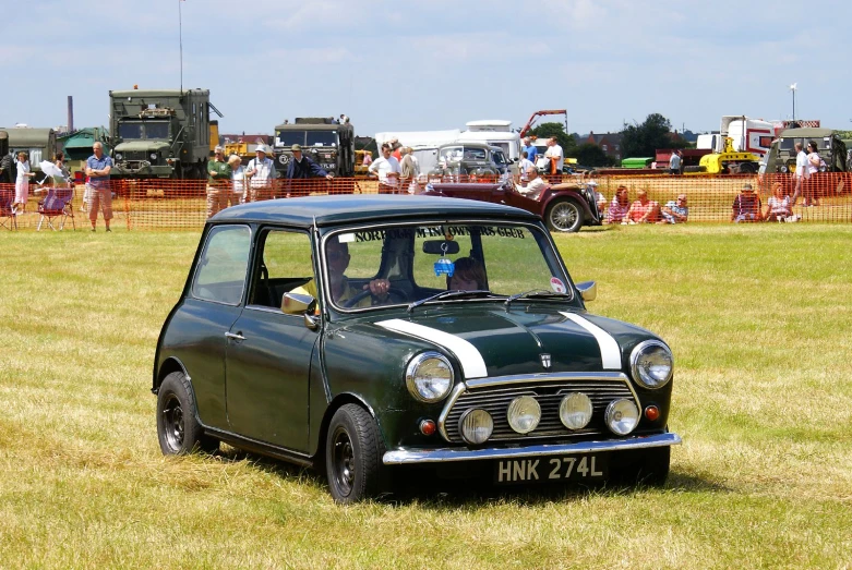 a green car parked on top of a lush green field