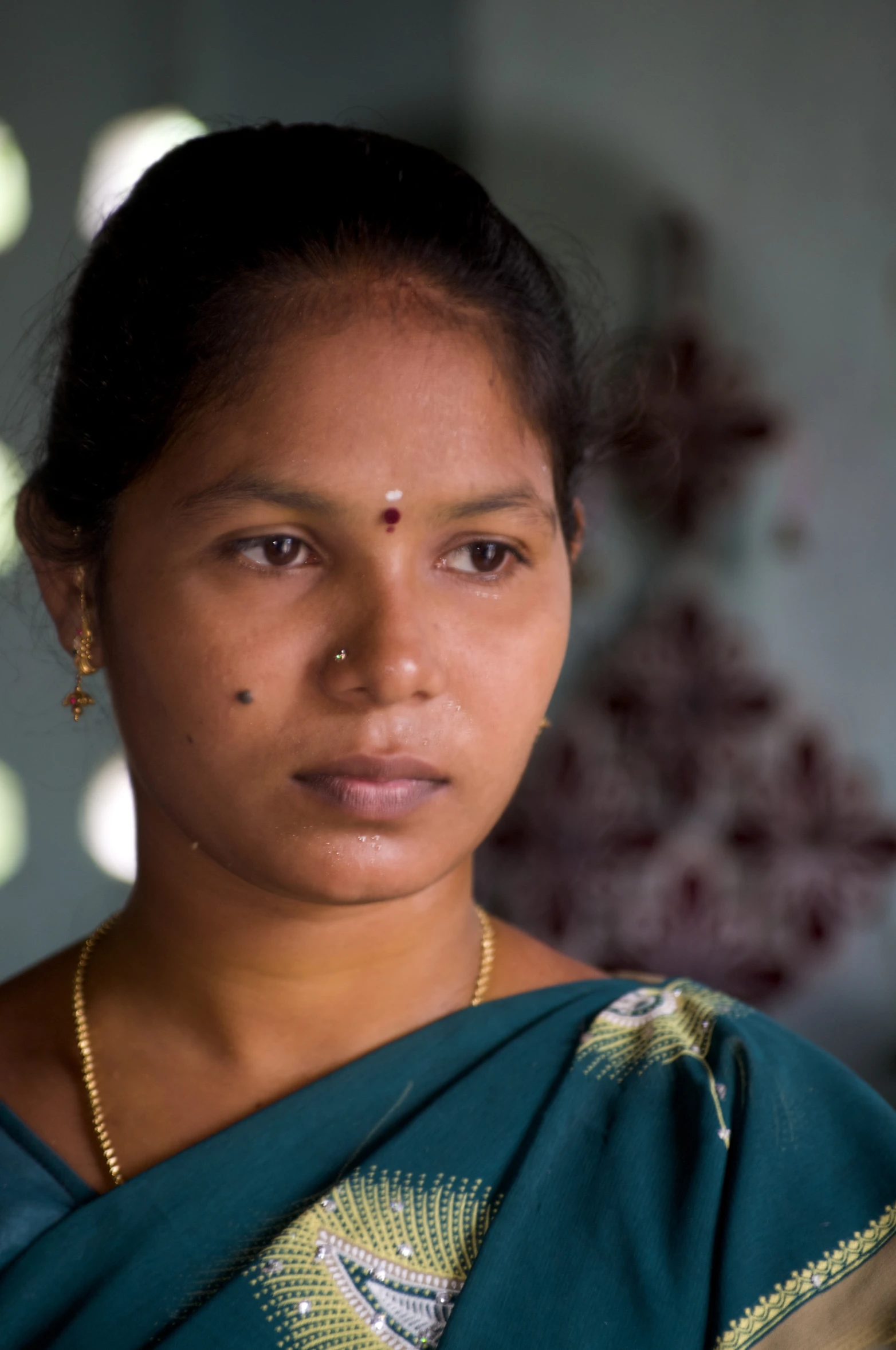 the beautiful woman in a green saree is holding her cellphone up