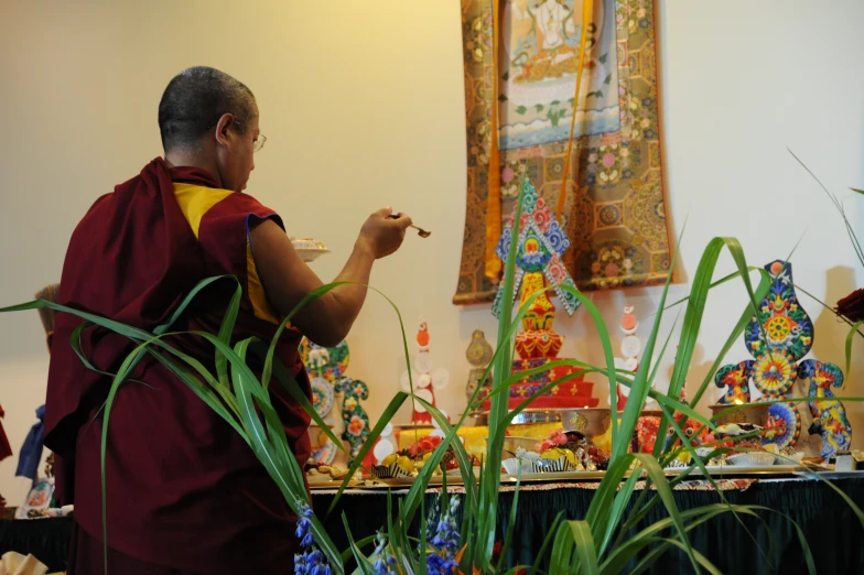 a man with a lot of buddha statues on the wall