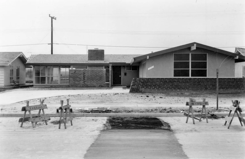 a black and white po of two lawn chairs in front of a building