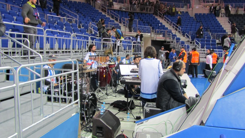 a group of people standing around some speakers in a stadium