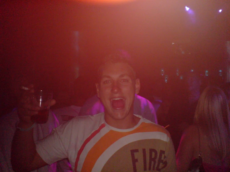 a guy smiling at the camera, with a frisbee t - shirt on