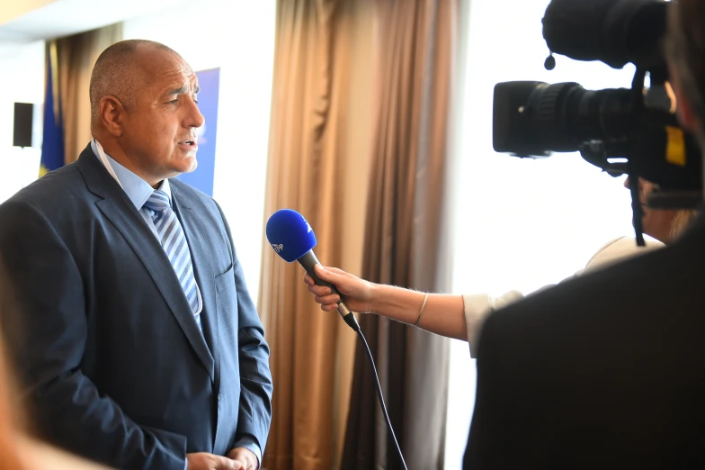 a man holding a microphone and giving a press conference