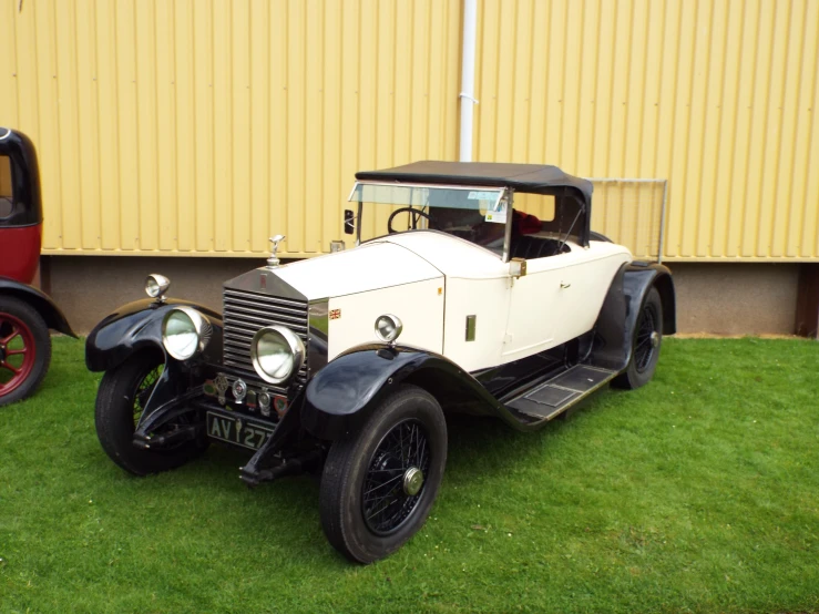 two older vintage style vehicles, one on display