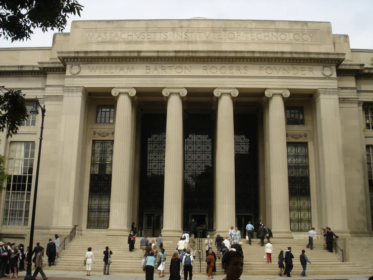 several people stand at the base of a large building