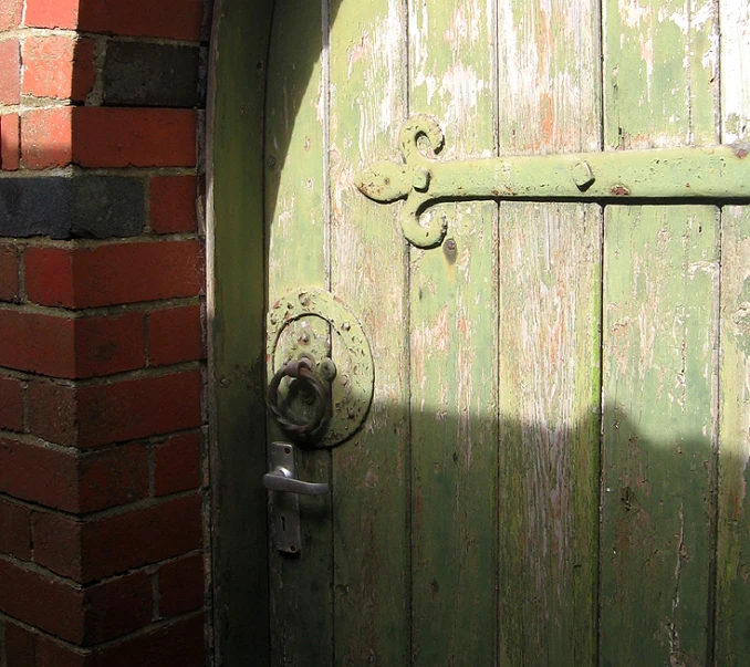 an open wooden door in front of a brick wall