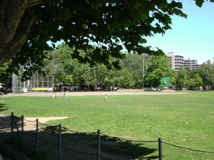 a field with s playing baseball in the background
