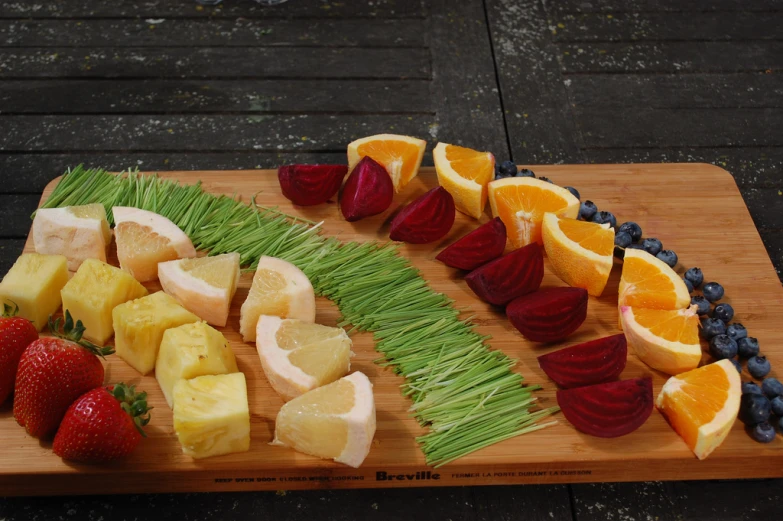 some assorted fruits sit on a wooden platter