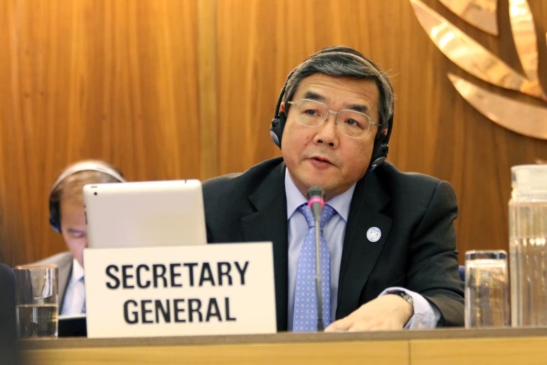 the secretary general is using a tablet at his desk