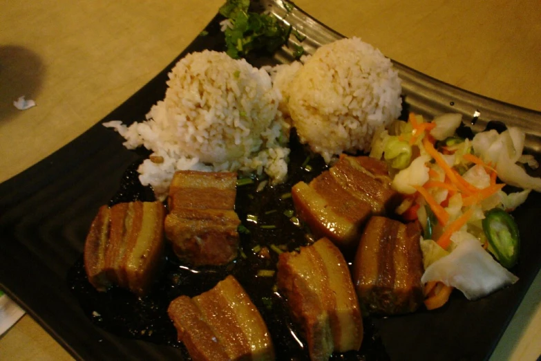 a plate with pieces of meat and some rice