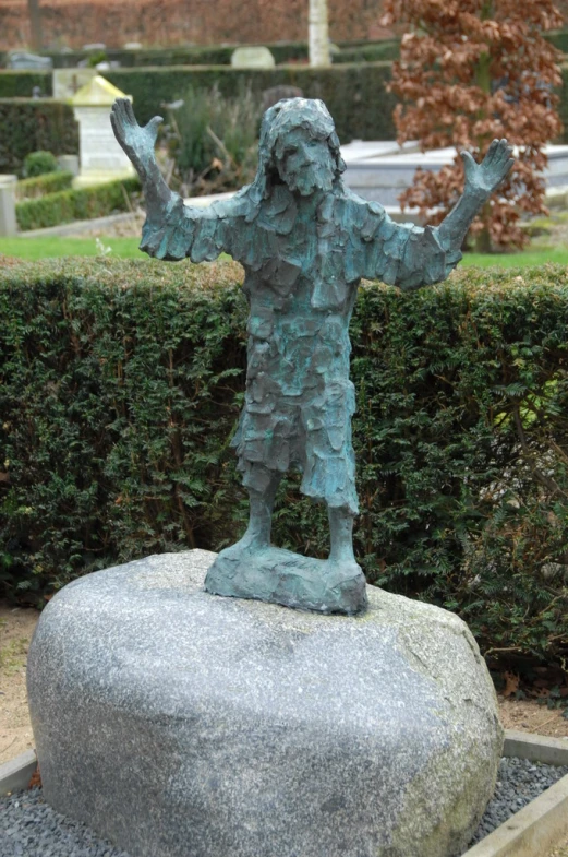 a statue of a man with his arms spread on a stone