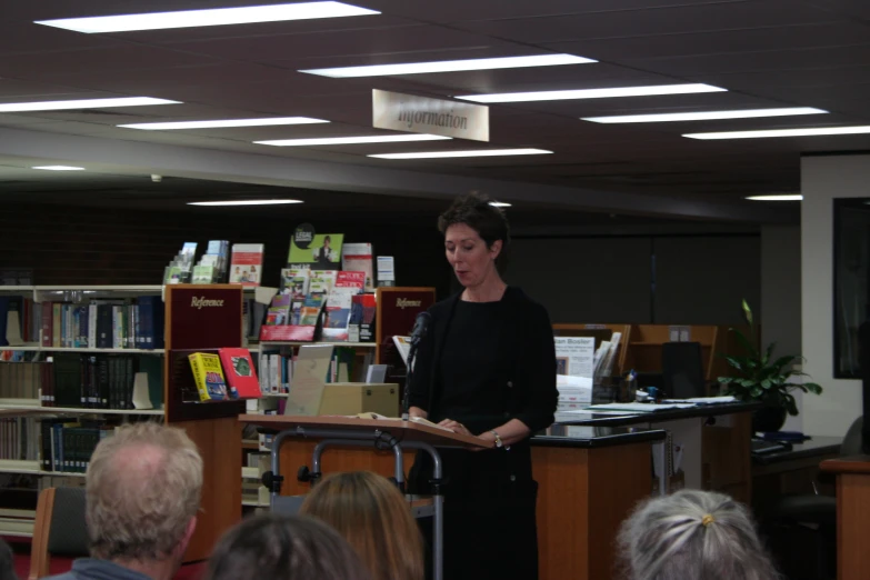 a woman standing at a book signing table