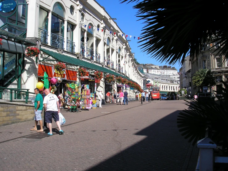 people and children in a street in a shopping district