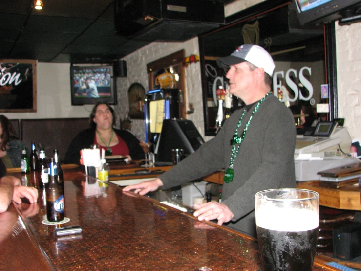 three people are at a bar with a man handing a woman soing