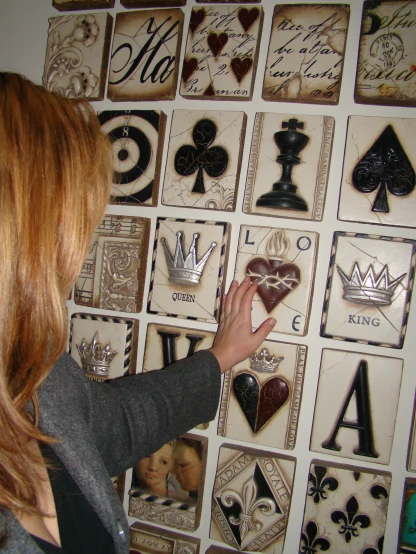 a woman is looking at a set of cards on the wall