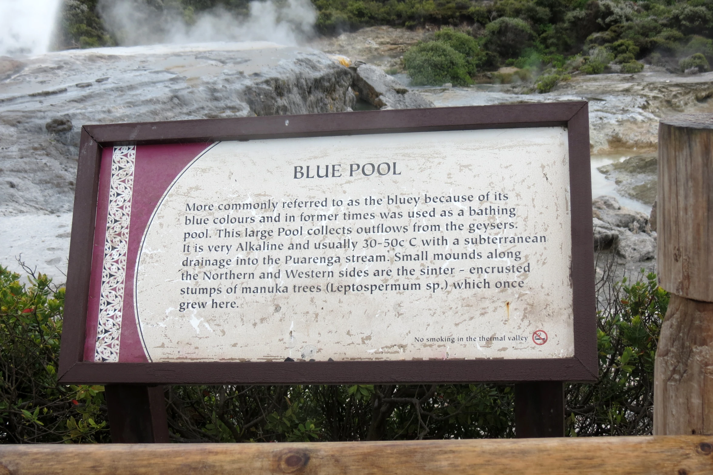 a plaque describing a blue pool at the foot of a waterfall